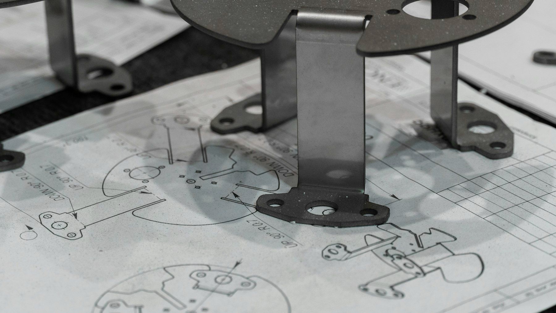 Machined parts resting on engineering drawings